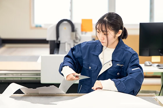 製図をカットする女性